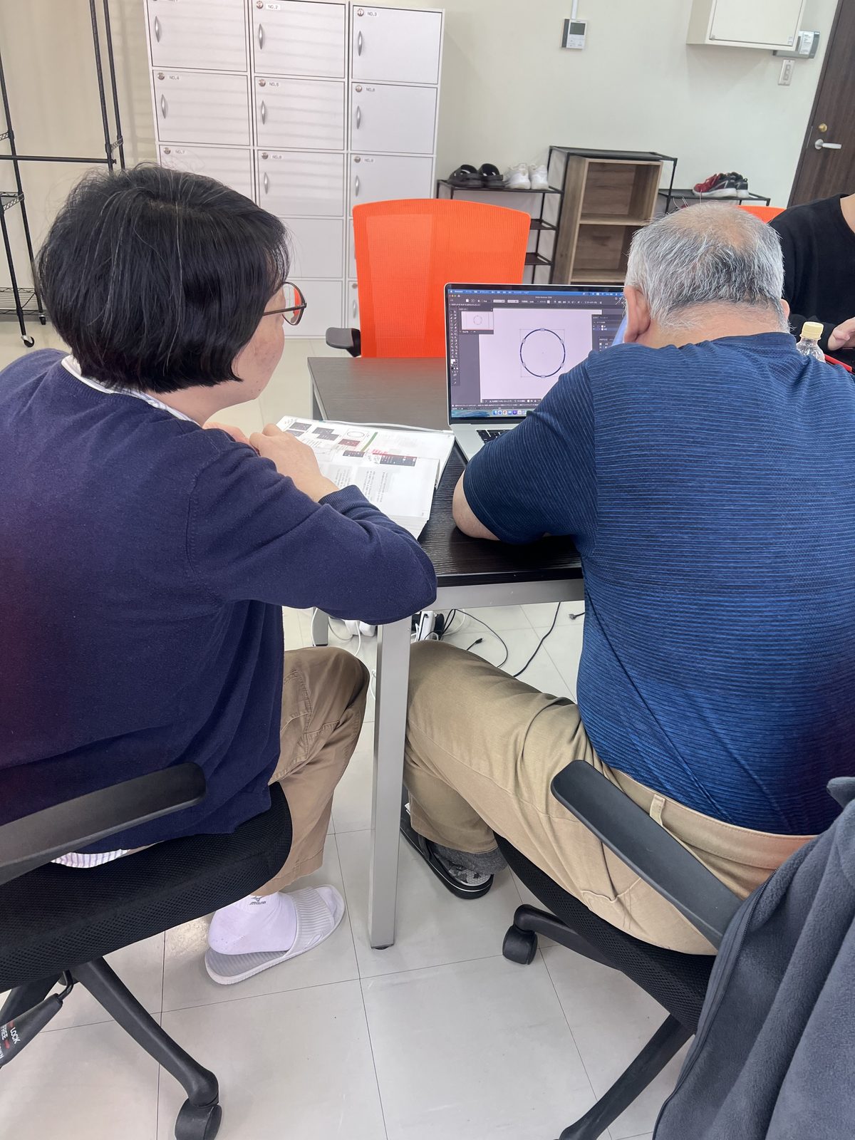 スタッフと利用者さんが一緒にノートパソコンで作業を進める様子